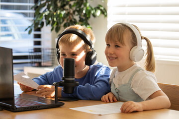 Joyful siblings sharing a laugh while recording a podcast at home. Blogging