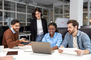 Confident business people discussing risky ideas working on laptop in office
