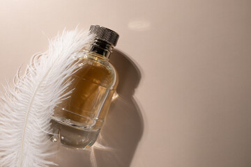 Gold perfume on the podium with soft feather, trendy cosmetic packaging, sensual aroma, floral...