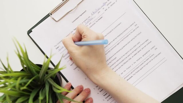 Commission agreement, hand fills out a document, business transaction, financial services, legal paperwork