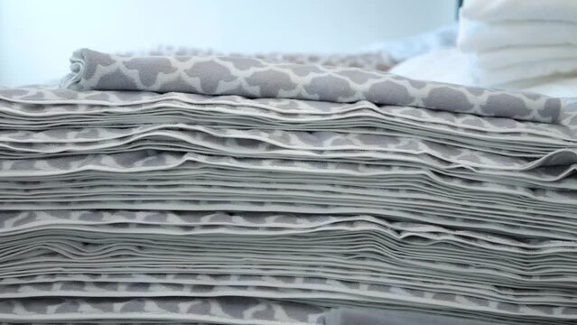 Stack of soft towels with gray-white patterns close-up, fabric with gray pattern