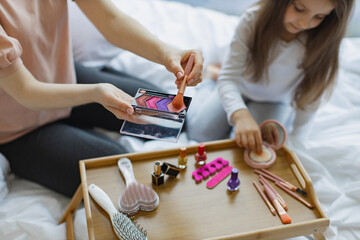 Cropped view of family mother and daughter relax using cosmetics on weekend. Happy woman in casual...