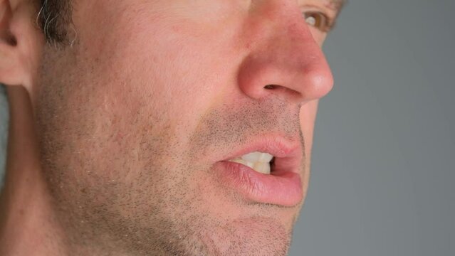Emotional man bared his teeth, irritability close-up.