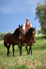 Beautiful Italian woman, riding her Maremmano horse and handling her yearling
