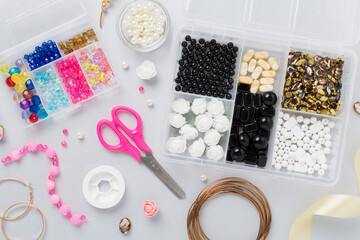 Tools and beads for making handmade jewelry on color background, top view