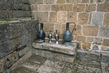 Antique metal vessels for water and wine. A copper jug in an ancient fortress. Antique handmade...