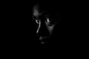 Young african american person in the dark, close up portrait