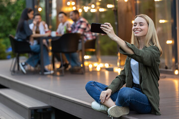 Fototapeta premium Woman making selfie with group of friends spending time making picnic