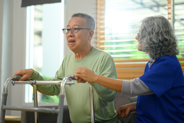 Nurse assisting elderly man using walking frame. Rehabilitation and Healthcare concept