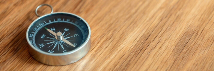 Banner of compass on wooden background with copy space using as direction