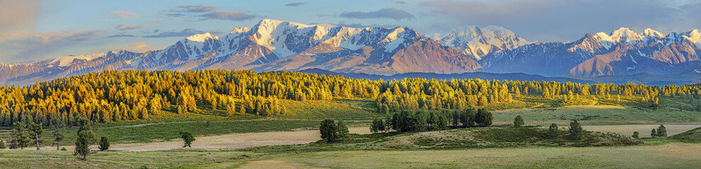 Panoramic view of mountain valley and snowy ridge, evening light