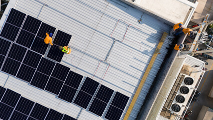 Aerial top view of a technician drone installing solar panels on the roof..