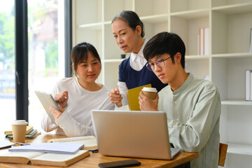 Mature female lecturer helping student during class. Education concept