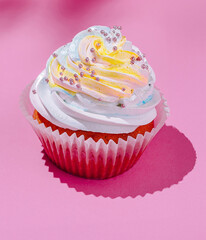 Colorful cupcake on pink background