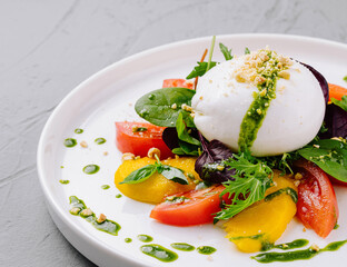 Fresh caprese salad with pesto drizzle on plate