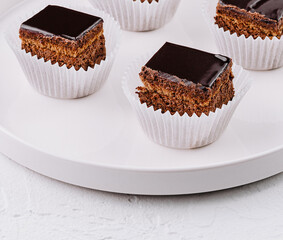 Chocolate glazed mini cakes on white plate