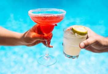 Male and female hands with glasses of delicious drinks are reaching out for toast. Strawberry...