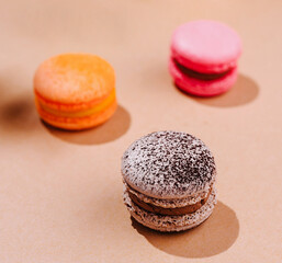 Colorful macarons on a warm beige background