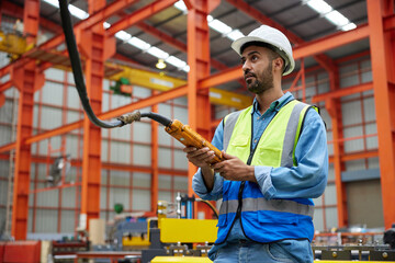 worker or engineer operating remote switch to control machine in the factory