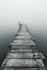 Obraz premium Wooden dock extending into a foggy lake