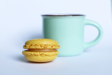 yellow macaroon and cup of coffee on white background.	