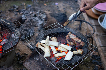 selective focus grilled mushrooms and pork on a charcoal grill