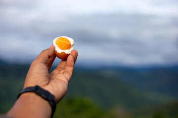 Selective focus boiled chicken eggs. Background, natural mountain view, high angle, green, bright sky. Simple breakfast amid nature on a high mountain.