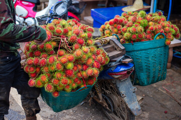 Selective focus, lots of red rambutans in a blue basket Fresh rambutans from farmers' gardens in...