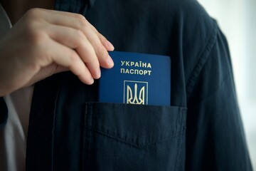 man puts Ukrainian passport in his pocket