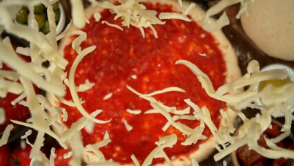 Super slow motion of falling grated cheese on pizza dough with camera follow and rotation. Filmed on high speed cinema camera, 1000 fps.