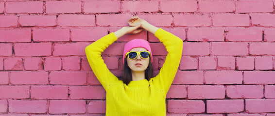 Portrait stylish young teenager girl in vivid colorful clothes, knitted yellow sweater and pink hat