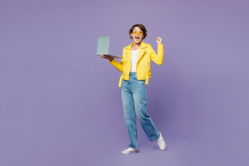 Full body young smiling IT woman wears yellow shirt white t-shirt casual clothes glasses hold use...