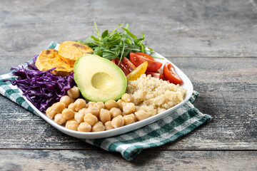 Healthy salad with avocado,lettuce,tomato and chickpeas on wooden table. Copy space