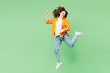 Full body young musician happy excited ginger woman she wear orange shirt white t-shirt casual...