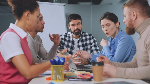 Manager looks on with disappointment as his team passionately debates during meeting, disagreement and lack of consensus. Dynamic of workplace discussions, leadership's role in navigating conflicts.