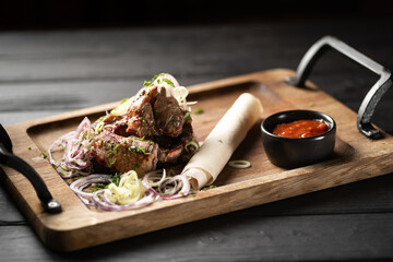 Delicious shish kebabs with lavash and sauce on wooden board