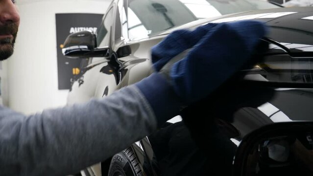 Staff wear Chemical protective clothing at work. Automobile industry. Car wash and coating business with ceramic coating.Spraying the varnish to the car. Concept of: Car protective, Service, Shine.	
