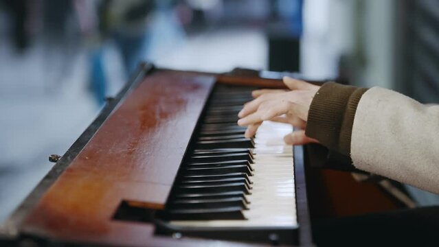 Street artist woman performer playing piano on public city street at night, slow motion