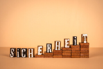 Security word in German. Wooden alphabet letters on a light background