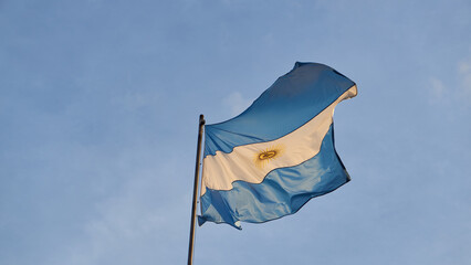 Details of an Argentine flag on a blue sky.
