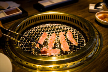 a grill where freshly prepared meat slices are being cooked