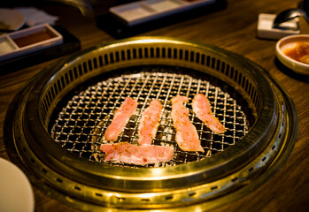 a grill where freshly prepared meat slices are being cooked