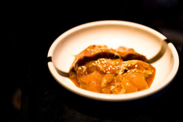 a bowl where freshly marinated chicken pieces are being served