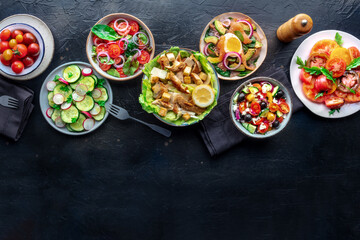 Fresh salads, overhead flat lay shot of an assortment. Variety of plates and bowls with green vegetables. Healthy food, top shot, with a place for text