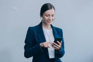 Portrait of a happy asian businesswoman using mobile phone isolated over white background