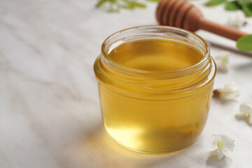 Honey with acacia blossoms on a white maeble background. Side view. Space for text.  
