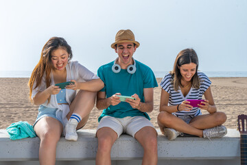 Multicultural group of trendy young friends having fun using smartphones and social media. Mobile games.