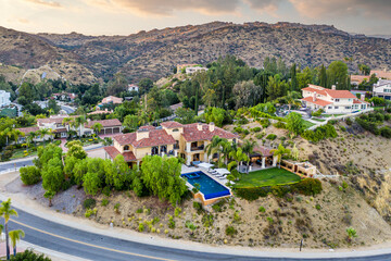 the home sits on top of a hill with mountains in the background