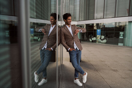 stylish businessman in an office building waiting while looking at his smartwatch
