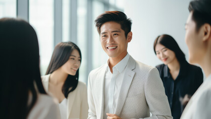 an Asian businessman in white suit shares insights and exchanges smiles with a conversation partner, fostering meaningful dialogue in the realm of business.